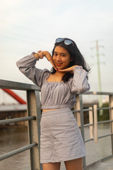 Fototapeta premium A young beautiful girl poses on an old bridge.