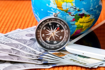 Five Hundred American Dollars, Compass, Globe of Planet Earth, Ipad on a Fabric Background Closeup. Travel  Concept.
