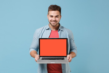 Smiling young bearded guy 20s in casual shirt posing isolated on pastel blue background studio...