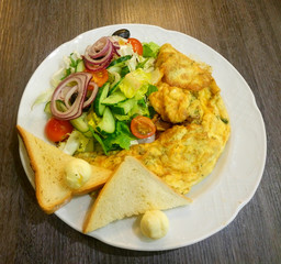 Breakfast. Omelet with croutons, butter and vegetable salad
