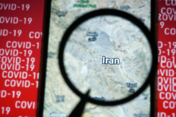 Iran country on google maps under magnifying glass with Red Covid-19 text Background.