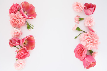 top view of pink spring flowers on white background with copy space