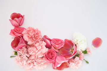 top view of pink spring flowers on white background with copy space