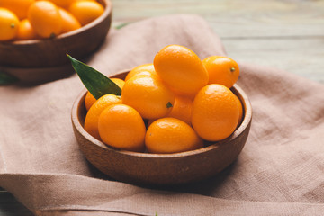 Plate with tasty kumquat fruit on table