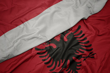 waving colorful flag of albania and national flag of indonesia.