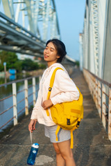 A young beautiful girl poses on an old bridge.