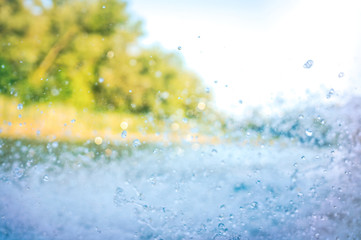 Splashing water in the rays of sunlight. Fun on the beach, background