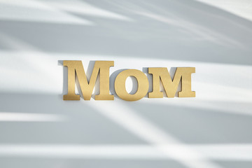 top view of mom lettering on white background with shadows