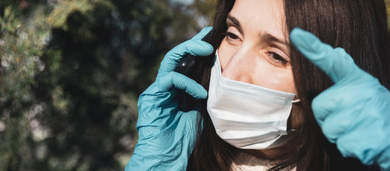 woman in a medical mask with a mobile phone