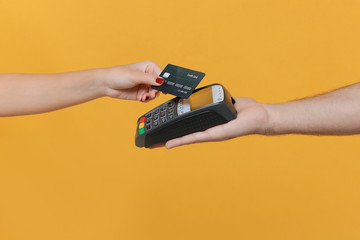 Close up cropped photo of female and male hold wireless modern bank payment terminal to process...