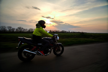 Obraz na płótnie Canvas man rides a motorcycle on a highway