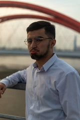 Man poses on an old bridge.