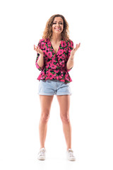 Excited emotional young woman laughing while trying to talk and explain gesticulating at camera. Full body isolated on white background. 