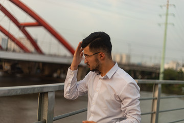 Man poses on an old bridge.