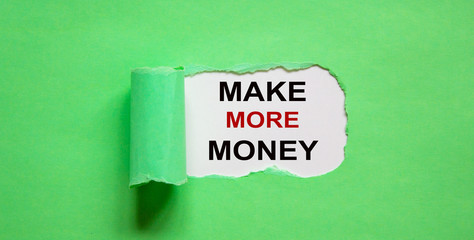 The text 'make more money' appearing behind torn green paper.