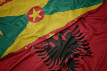 waving colorful flag of albania and national flag of grenada.