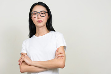 Obraz premium Young beautiful Asian nerd woman wearing eyeglasses with arms crossed