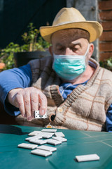 elderly ma playing dominoes during coronavirus epidemic quarantine