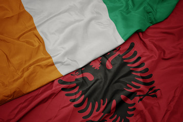 waving colorful flag of albania and national flag of cote divoire.