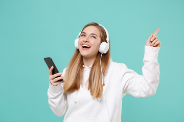Funny young woman girl in casual white hoodie posing isolated on blue turquoise wall background....