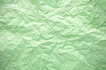 Green crumpled paper background. Twisted green paper. Seamless pattern.