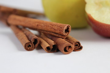 cinnamon sticks and apples on a white background