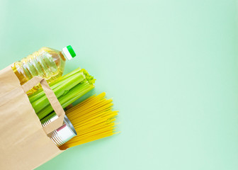 Coronavirus food supplies concept. Food layout with pasta, cooking oil, canned food, celery in...
