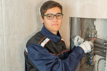 Portrait of a professional plumber, a young worker working with central heating