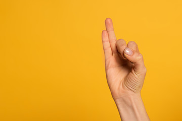 Cropped view of woman using sign language isolated on yellow