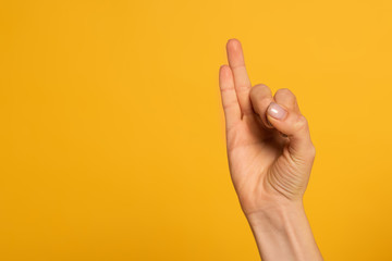 Naklejka premium Cropped view of woman using sign language isolated on yellow