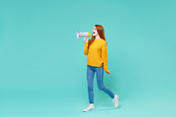 Funny young redhead woman girl in yellow knitted sweater posing isolated on blue turquoise wall...