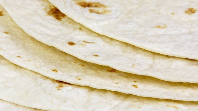 Tortilla flat bread wraps in a pile slowly panning close up with a shallow depth of field