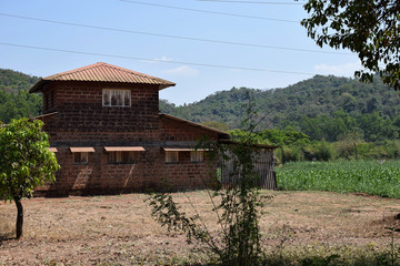 Picture of old warehouse surrounded by agricultural land In Indian village constructed with brown bricks