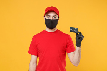 Delivery man red cap blank t-shirt uniform mask gloves isolated on yellow background studio Guy employee work courier hold credit card Service quarantine pandemic coronavirus virus 2019-ncov concept.