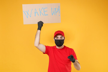 Delivery man in red cap t-shirt uniform face mask gloves hold broadsheet placard isolated on yellow background studio Guy employee working courier Service pandemic coronavirus virus 2019-ncov concept.