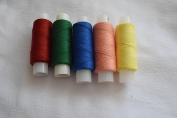 A set of sewing threads, needles, pins.