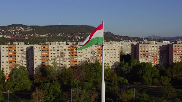 Hungary Budapest. Wind waving a  Hungarian flag. Old Buda's houses are in the backrund what are decorated with sword play figures
