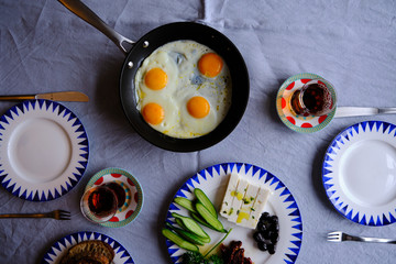 Traditional Turkish Breakfast with Sunny Side Up Eggs, Feta Cheese, Tea, Olives and Cucumber. Breakfast for two