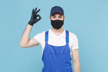 Delivery man in cap t-shirt coveralls uniform sterile face mask gloves isolated on blue background studio. Guy employee courier Service quarantine pandemic coronavirus virus covid-19 2019-ncov concept