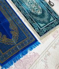Prayer rugs on a carpet in a house,
