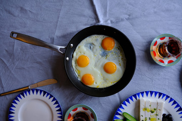 Traditional Turkish Breakfast with Sunny Side Up Eggs, Feta Cheese, Tea, Olives and Cucumber. Breakfast for two