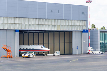 The pushback tug taxing the business jet from the hangar to the taxi strip