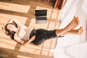 woman laying on floor of the room near big window. resting after hard work