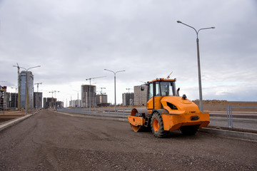 Soil Compactor at construction site. Vibration single-cylinder road roller for leveling soil, gravel, concrete, or asphalt in the construction of roads and foundation. Road Construction Equipment