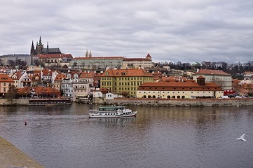 A boat in the Vltava river with the castle of Prague in background (Prague, Czech Republic, Europe)