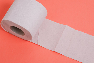 Expanded roll of toilet paper on a colored background. The concept of cleaning and personal hygiene.