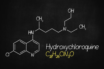 Hydroxychloroquine , chloroquine medicine substance. Drug introduced as treatment for coronavirus SARS-CoV-2. Active in COVID-19 supportive therapy. Chemical formula written with chalk on board.