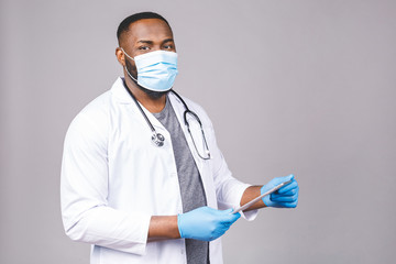 African american doctor man in face mask gloves isolated on grey background. Epidemic pandemic...