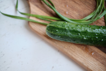 green onions and cucumber on the board