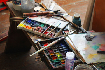 Watercolor paints and brushes on the table